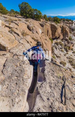 Karen Rentz hiking trail cut into soft volcanic tuff rock by footwear through the years, at the Tsankawi Prehistoric Sites in Bandelier National Monum Stock Photo