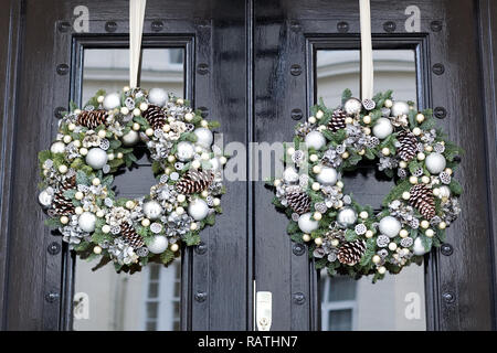 Decorative Christmas wreaths handing on a front door in London Stock Photo