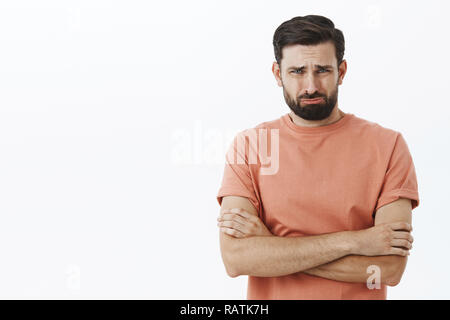 I thought you loved me. Crying bearded 30s guy frowning grimacing in sorrow holding hands crossed over body in defensive pose, whining, offended and upset with break-up, complaining on hard life Stock Photo
