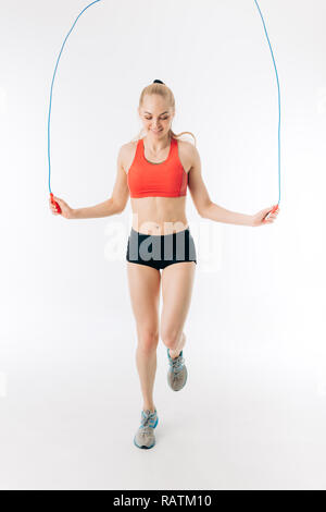 happy young sport girl is using a skipping rope during workout Stock Photo
