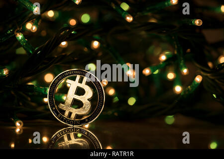 Bitcoin cryptocurrency physical coin placed next to Christmas lights Stock Photo
