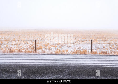 Snow covered Rt. 285; ranch pasture & barbed wire fence near Jefferson; central Colorado; USA Stock Photo