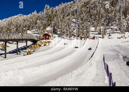 December 26, 2018 South Lake Tahoe / CA / USA - Tourists tubing on the slopes of Heavenly Ski Resort on a sunny winter day Stock Photo