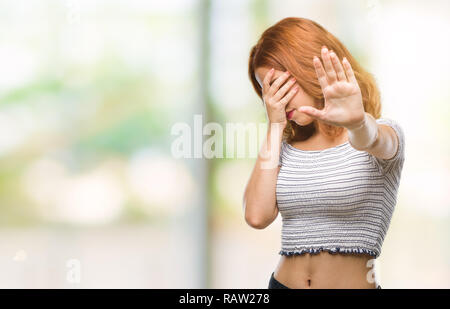 Young beautiful woman over isolated background covering eyes with hands and doing stop gesture with sad and fear expression. Embarrassed and negative  Stock Photo