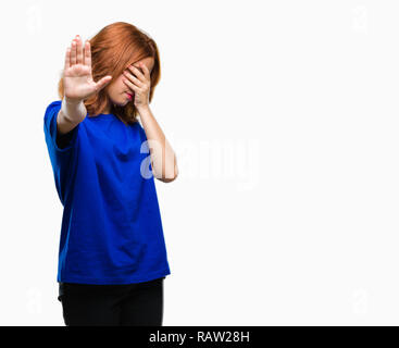 Young beautiful woman over isolated background covering eyes with hands and doing stop gesture with sad and fear expression. Embarrassed and negative  Stock Photo