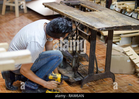 Carpenter restoring old sawing machine Stock Photo