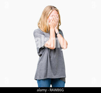 Beautiful young woman wearing oversize casual t-shirt over isolated background with sad expression covering face with hands while crying. Depression c Stock Photo