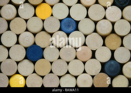 The tops of synthetic, colorful wine corks are shown loosely stacked in a closeup view. Stock Photo