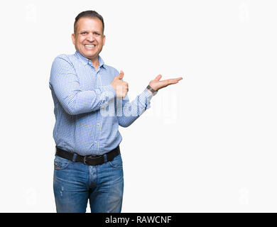 Middle age arab business man over isolated background Showing palm hand and doing ok gesture with thumbs up, smiling happy and cheerful Stock Photo