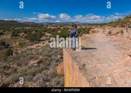 Karen Rentz on trail along a cliff at the Tsankawi Prehistoric Sites in Bandelier National Monument near Los Alamos, New Mexico Stock Photo