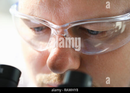 Male scientist looking through binocular Stock Photo