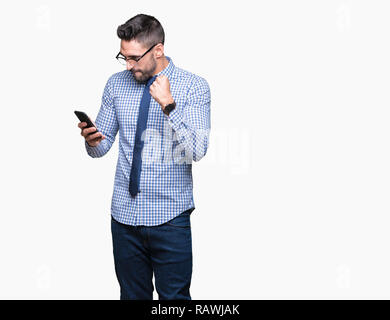 Young business man using smartphone over isolated background screaming proud and celebrating victory and success very excited, cheering emotion Stock Photo