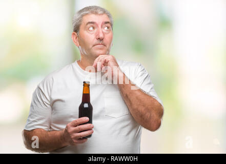 Handsome senior man drinking beer bottle over isolated background serious face thinking about question, very confused idea Stock Photo