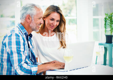 Couple looking in laptop on table Stock Photo