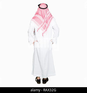 Arabian business man with long hair wearing traditional keffiyeh scarf standing backwards looking away with arms on body Stock Photo