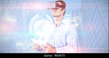 Composite image of businessman holding tablet while wearing vr glasses Stock Photo