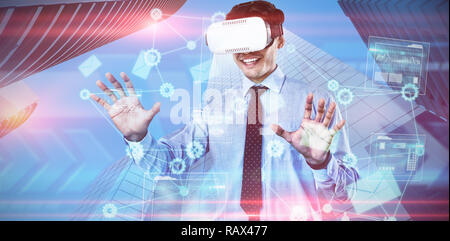 Composite image of happy businessman using vr glasses Stock Photo