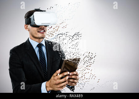 Composite image of businessman wearing vr glasses while using tablet Stock Photo
