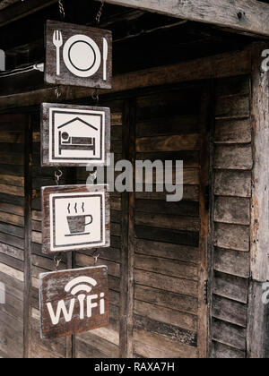 Food, Room, Drink and Free Wi-Fi wooden sign on vintage wooden wall background of homestay in Thailand, Dark tone Stock Photo
