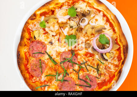 half seafood and half pepperoni pizza on thin crust, including shrimp, squid, pepperoni, shellfish, onion, and coriander or cilantro Stock Photo