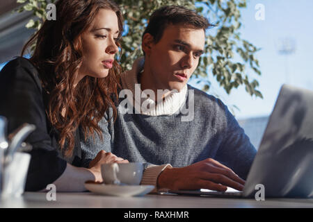 Young man and woman working in front of the laptop. Team meeting, work process. Stock Photo