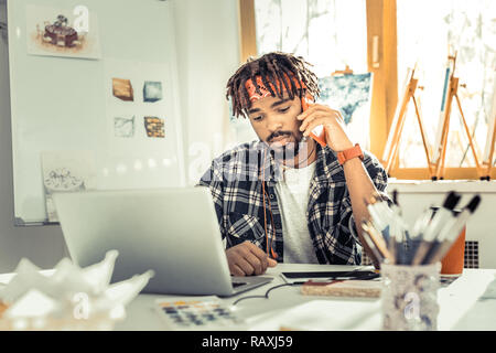 Stylish interior designer wearing squared shirt and red headband Stock Photo