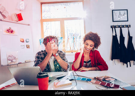 Couple of interior designers laughing enjoying process of work Stock Photo
