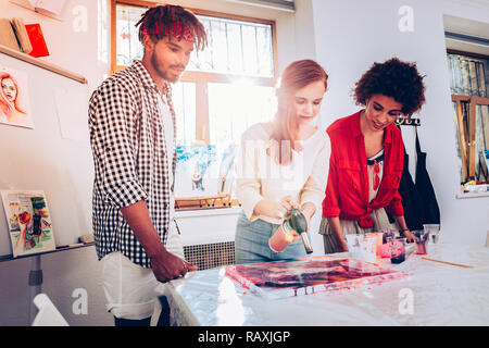 Man with dreadlocks taking his girlfriend to painting master class Stock Photo