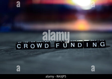 Crowd funding on wooden blocks. Business and finance concept. Cross processed image with bokeh background Stock Photo