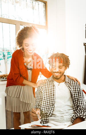 Couple of artistic creative artists painting in big light studio Stock Photo
