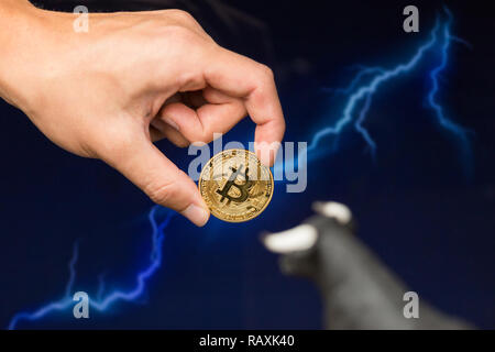 Man holding Bitcoin gold coin in front of lightning network concept background Stock Photo