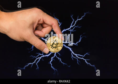 Man holding Bitcoin gold coin in front of lightning network concept background Stock Photo