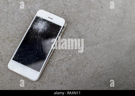 Smartphone mobile fall on the cement floor with touch screen broken. Stock Photo