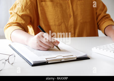 Close-up of female hands.  writing something in her office Stock Photo
