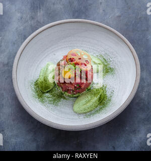 Fresh tuna tartar with lime, avocado sauce and yolk, restaurant dish Stock Photo
