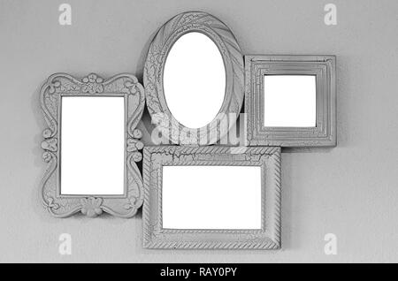 A collage of four empty photo frames on a gray wall, decor layout. Isolated on white background. Stock Photo