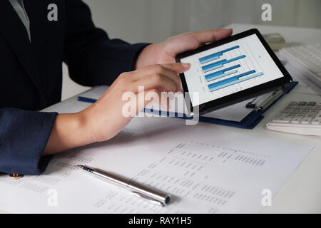 Women working in office. financial analysis with charts on pad for business, accounting, insurance or finance concept Stock Photo