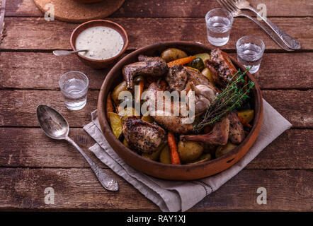 Rabbit baked with potatoe and herbs in a pot, copy space. Stock Photo