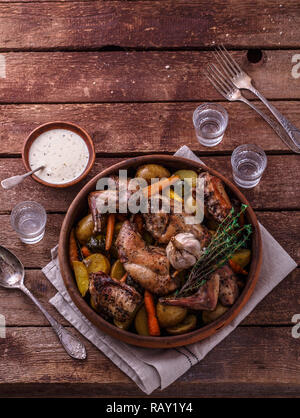 Rabbit baked with potatoe and herbs in a pot, copy space. Stock Photo