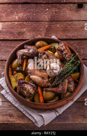 Rabit with root vegetables and herbs on wooden background, copy space. Stock Photo