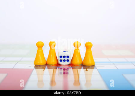 Portrait of yellow pawns with dice on the ludo game. Stock Photo