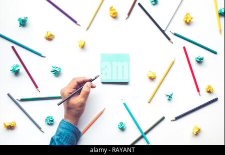 Male hand writing on notepaper with colorful pencil on white background.Business creativity and education ideas concepts Stock Photo