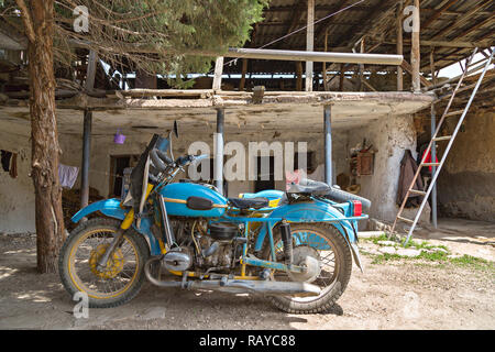 Old soviet blue motorbike in a village house, in Areni, Armenia. Stock Photo
