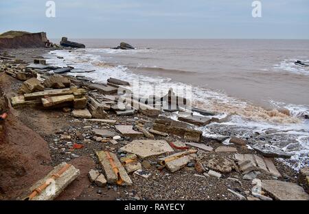 Debris on the beach, the result of coastal erosion. Stock Photo