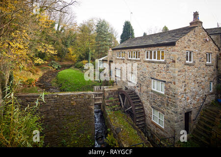 Marpel Bridge in Stockport, Cheshire a water wheel on the side of a house on a stream connecting with the River Goyt in the village Stock Photo