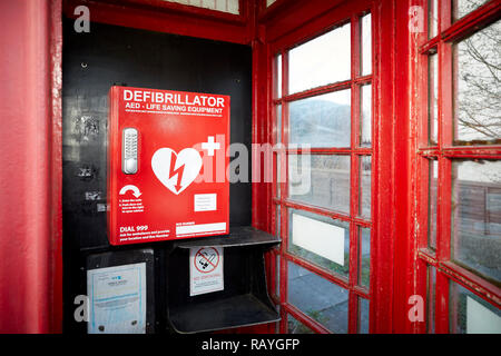 Emergency defibrillation automated external defibrillator (AED) located in an old red telephone box in a Lancashire Village Stock Photo