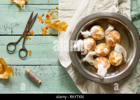 Preparation of Easter eggs for dying with onion peels: eggs with a pattern onion peels. Stock Photo