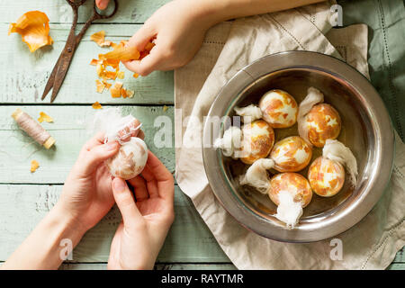 Preparation of Easter eggs for dying with onion peels: eggs with a pattern onion peels. Stock Photo