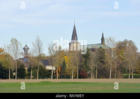 View to Meerbusch Lank-Latum, North Rhine-Westfalia, Germany, church St. Stephanus und old water tower in fall. Stock Photo