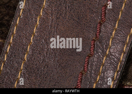 Top macro view of colorful different thread stitches on brown leather footwear or clothes. Horizontal color background. Stock Photo